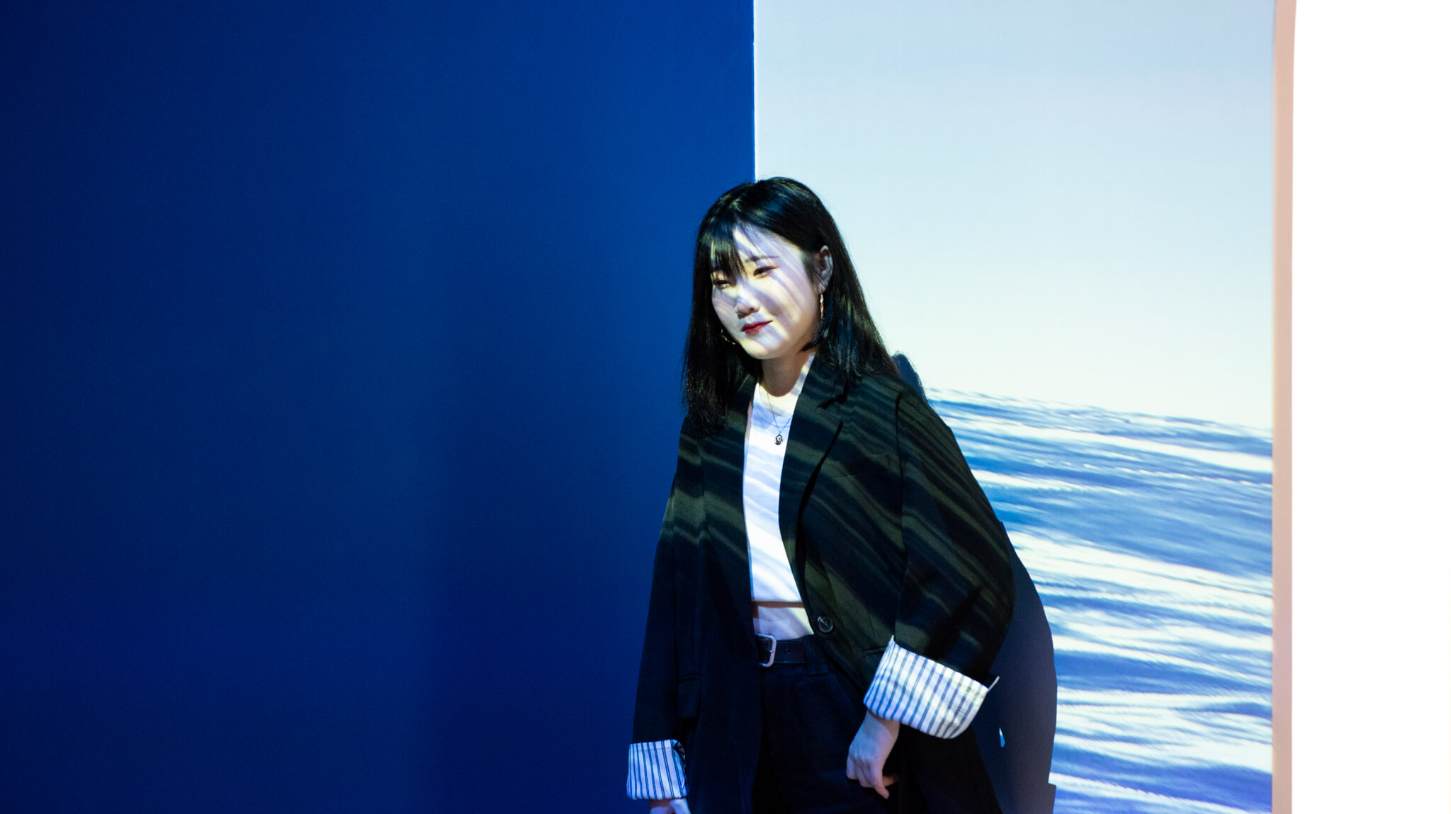 A woman stands in front of an immersive experiential brand event in Shanghai.