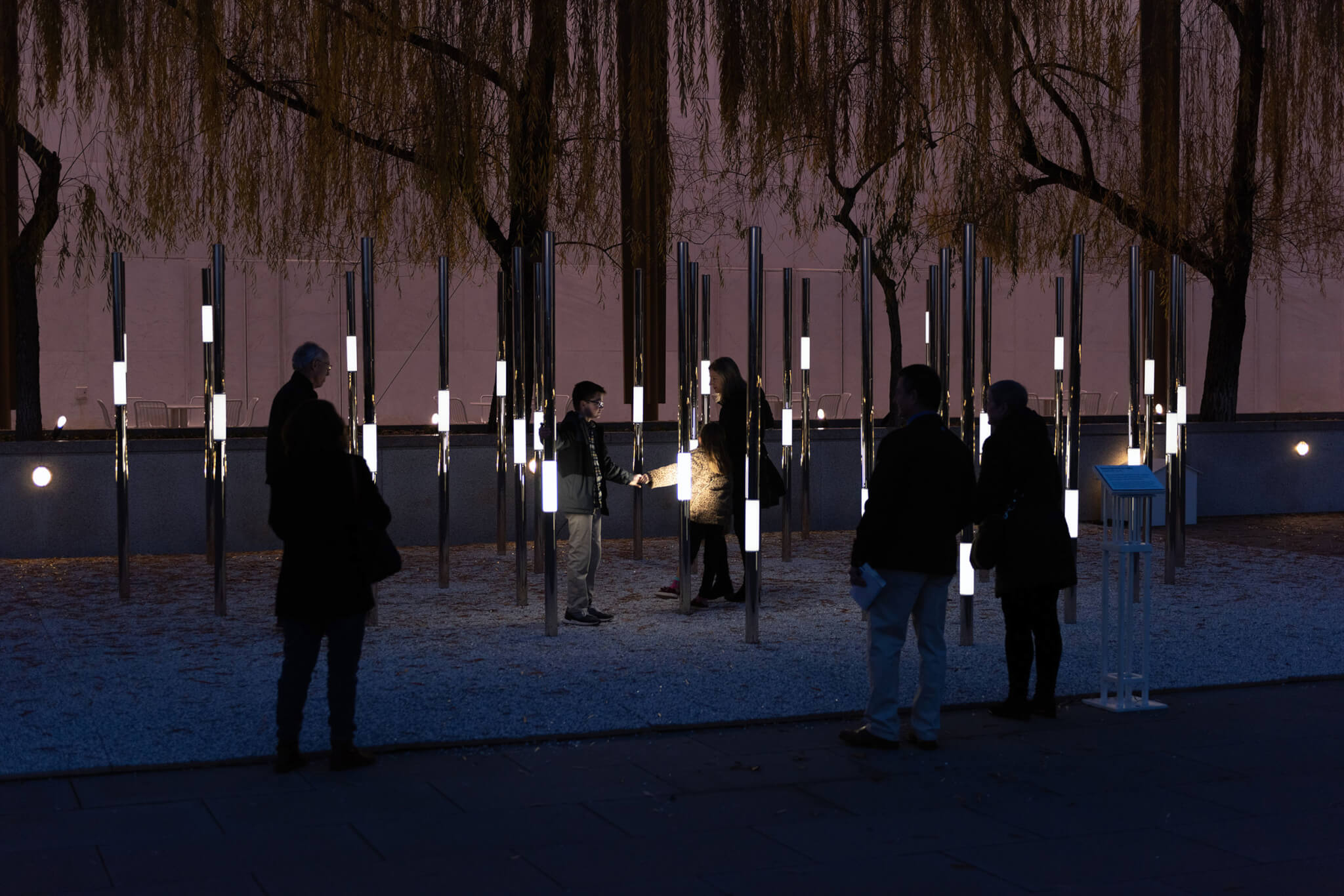 A group of people interact with Heartfelt, an interactive permanent outdoor sculpture.